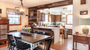 Una cocina amplia con una isla grande, armarios de madera e iluminación colgante.