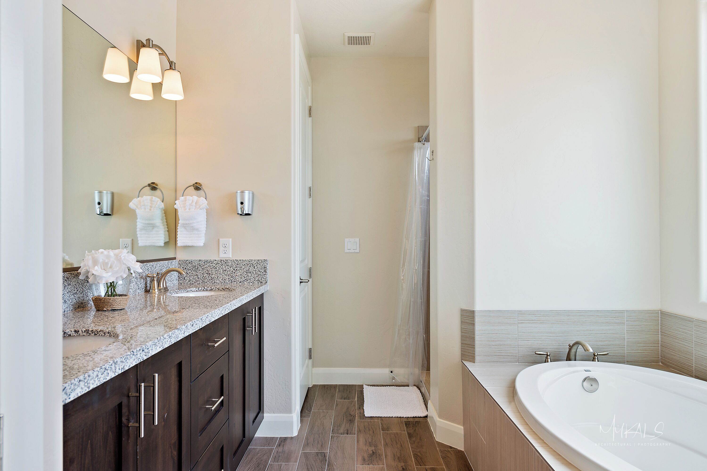 A modern bathroom with a large sink, vanity, and bathtub.
