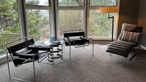 Une pièce d’angle avec une grande fenêtre, une table avec des chaises et un canapé.