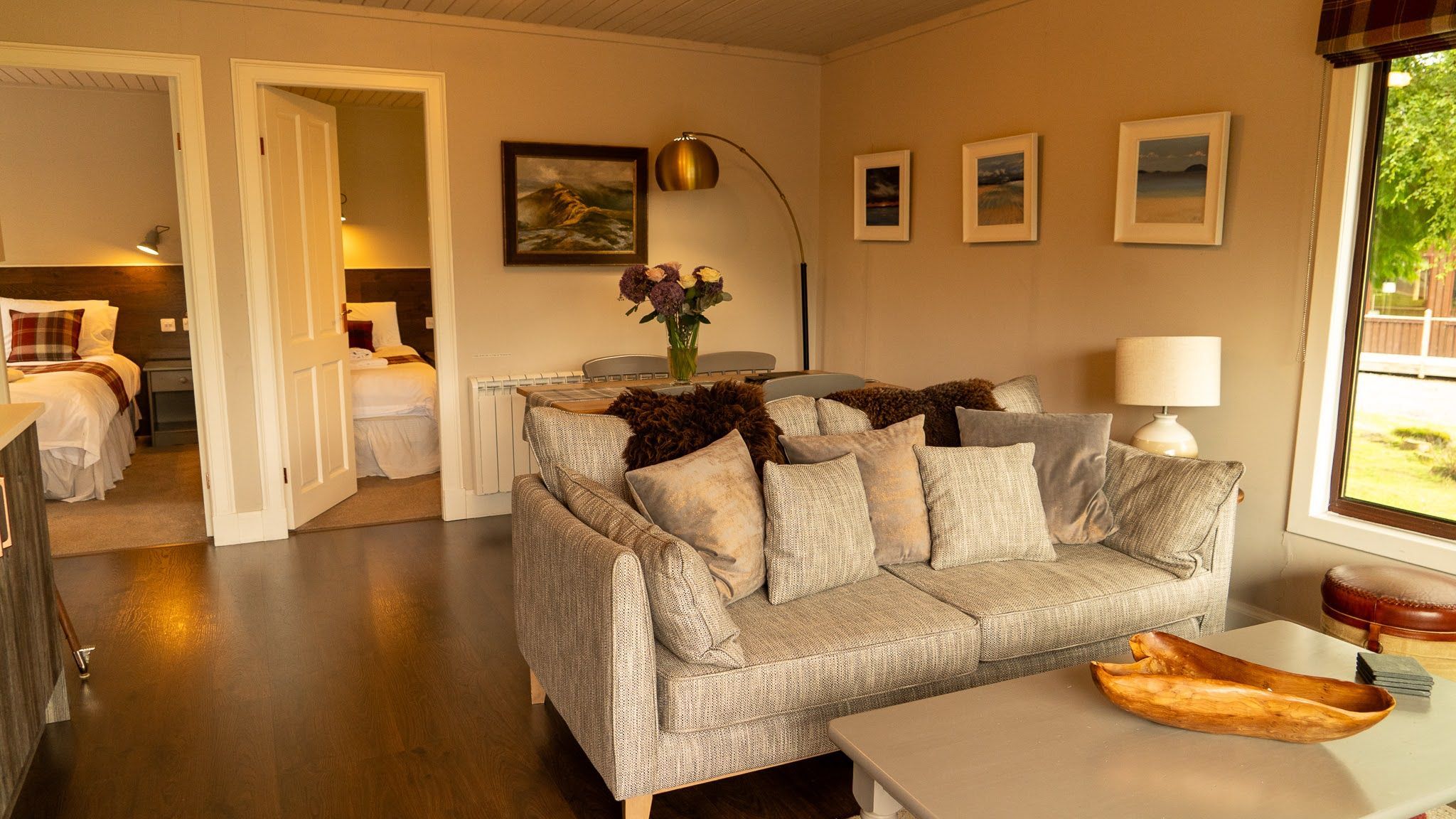 A cozy living room with a sofa, a dining table, and a window with a view.