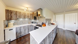 Una cocina moderna con una isla grande, armarios de madera y salpicadero de azulejos.