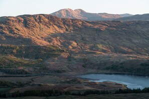 A mountainous landscape with a lake. - Beautiful 4 star, 2 bedroom chalet with stunning loch and mountain views (Crianlarich)