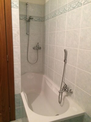 Tina con regadera, secadora de cabello, bidet, toallas 