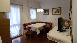 Un comedor con una mesa, sillas y un televisor.