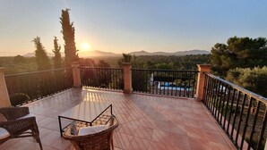 A balcony with tiled flooring, wicker furniture, and a view of a swimming pool and mountains. - Majorcan finca in a paradise area with no neighbours  (Santa Margalida)