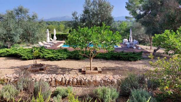 A landscaped outdoor area with a pool, lounge chairs, and a view of distant mountains. - Majorcan finca in a paradise area with no neighbours  (Santa Margalida)