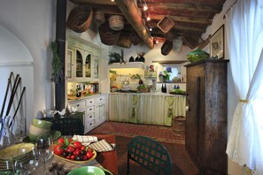 Une cuisine rustique avec des meubles en bois, des paniers suspendus et une variété d’ustensiles de cuisine.