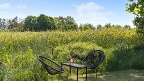 Een tafel en twee stoelen in een veld vol gele bloemen.