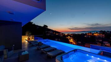 Relax by the pool with a serene view of the surrounding landscape and distant town.