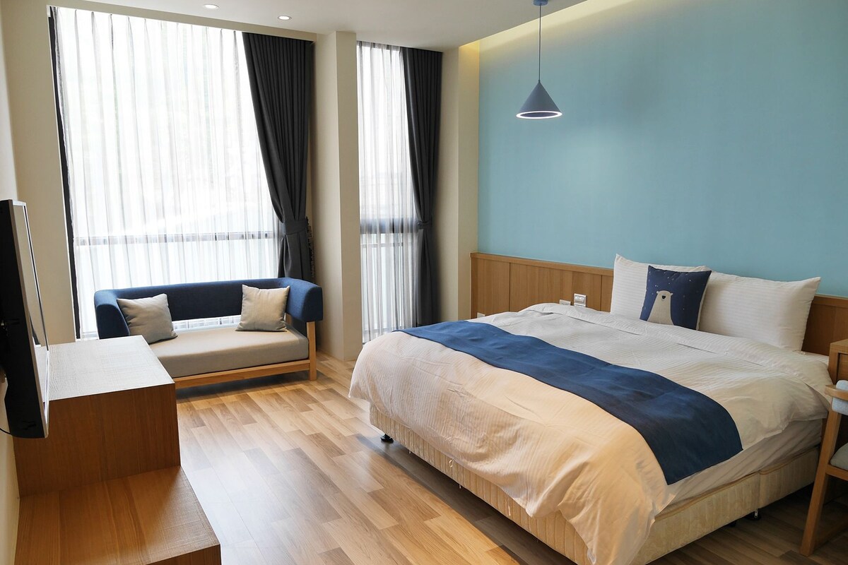 Una habitación de hotel con una cama, un sofá, un escritorio y un televisor.
