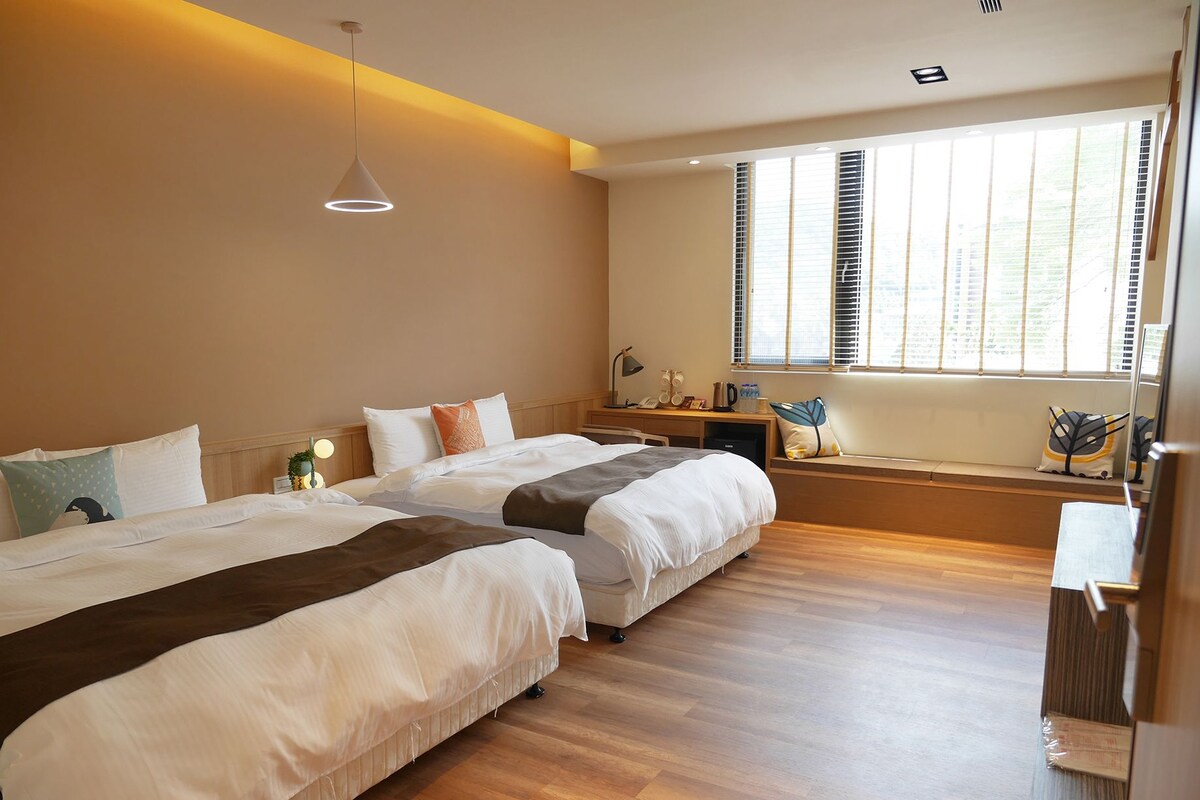 Un dormitorio moderno con dos camas, un escritorio y una ventana con persianas.