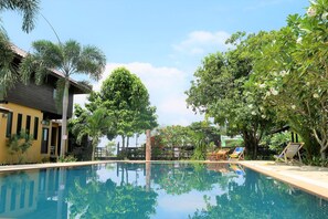 Alberca al aire libre y camastros