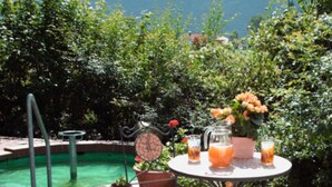 Un espace aménagé au bord de la piscine, avec une table, des chaises et une horloge.