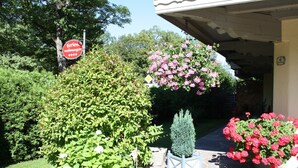 Ein gepflegter Garten mit verschiedenen Pflanzen und einem Schild, das ein Restaurant anzeigt.