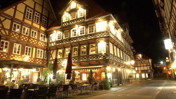 A traditional European building with multiple stories, featuring exposed wooden beams and a series of windows.