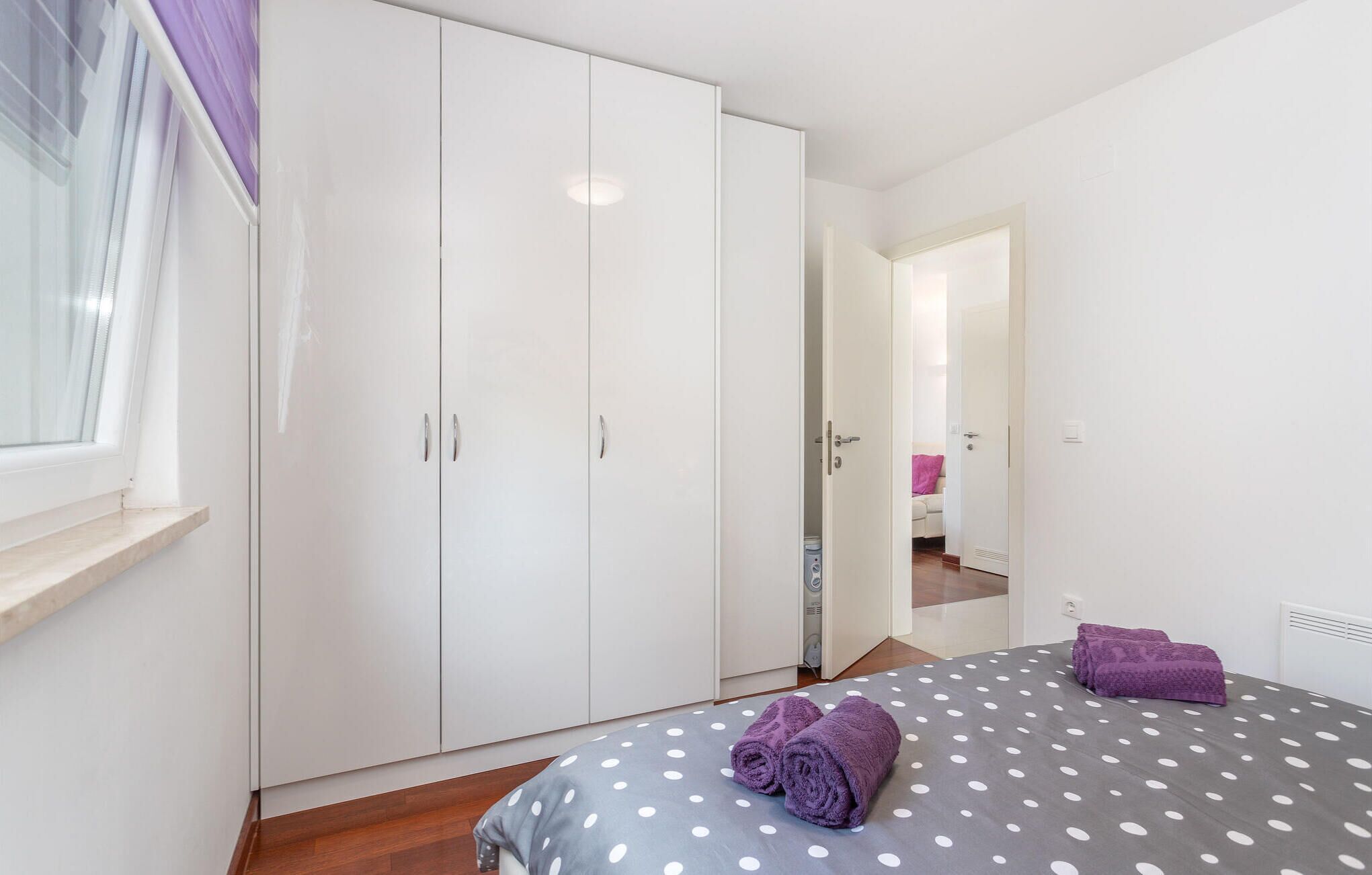 Een slaapkamer met een bed, een kledingkast en een raam.