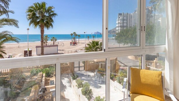 A balcony with a view of a beach and ocean.