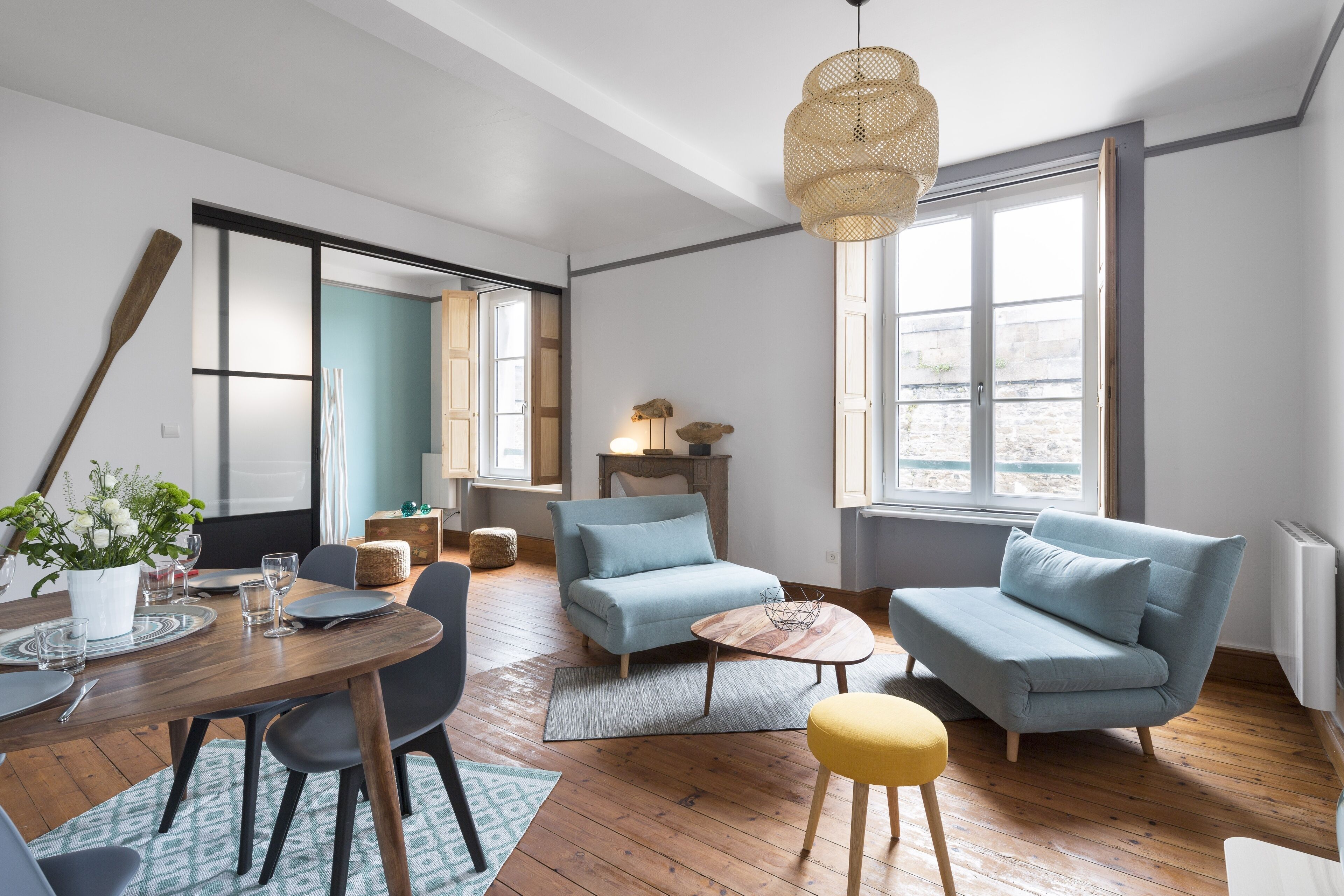 Una sala de estar moderna con comedor, que incluye un sofá, sillones, una mesa de centro y una mesa de comedor para cuatro personas.