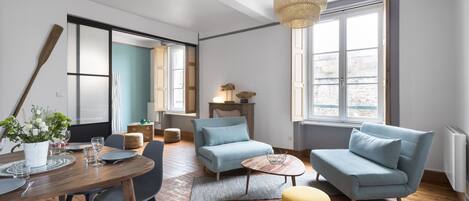 Una sala de estar moderna con comedor, que incluye un sofá, sillones, una mesa de centro y una mesa de comedor para cuatro personas.