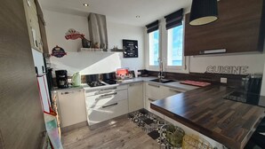 Een moderne keuken met een houten aanrecht, een ingebouwde oven en een spoelbak.