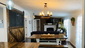 Una sala de estar acogedora con chimenea, muebles de madera y una araña.