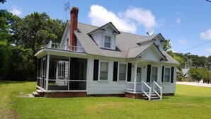 A single-story house with a porch, a chimney, and a satellite dish. - Adorable Cape Cod House in a Little Fishing Town (Marshallberg)