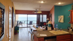 A kitchen with a granite countertop, a dishwasher, and a dining area with a table and chairs. - As seen on HGTV! Sonoran Sea, Beach Front, Stunning Ocean Views,2B/2B, 8th Floor (Puerto Peñasco)