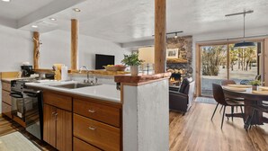 Une cuisine moderne avec des meubles en bois, un îlot central et une cheminée en pierre.