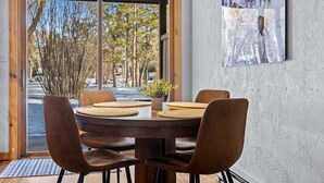 Un coin repas avec une table ronde, six chaises et une plante en pot.