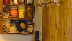 A kitchen shelf with various cooking utensils, a wine bottle, and a spice rack. - Historic Pioneer Cabin in the Heart of Canyon Country (Escalante)