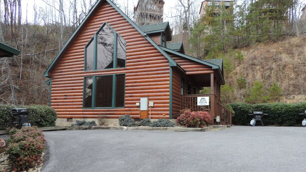 A log cabin with a large window, a porch, and a sign reading "Bear Footin". - Excellent Mountain View’s, Hot Tub, WIFI, Minutes to Gatlinburg (Gatlinburg)