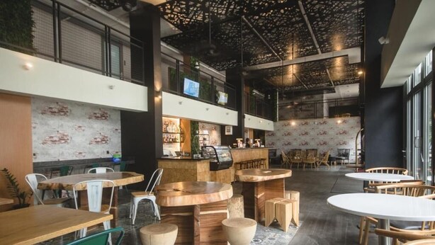 A modern interior with a bar area, seating arrangements, and a patterned floor. - Cuna Hotel (El Nido)