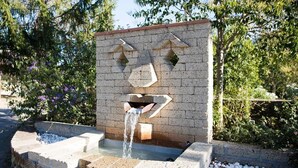 A water feature with a geometric design, surrounded by a stone border and pebbles. - Il Borgo Centro Vacanze (Guardistallo)