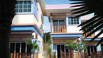 Un edificio de dos pisos con un balcón y una escalera que conduce a la entrada.