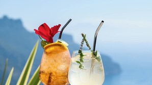 Two cocktails on a table with a floral tablecloth, set against a mountainous backdrop. - Villa Amore (Ravello)