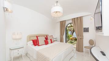 A bedroom with a bed, bedside table, and a TV.
