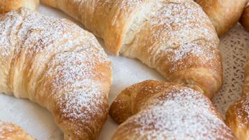 En bakke med nybagte croissanter drysset med flormelis.