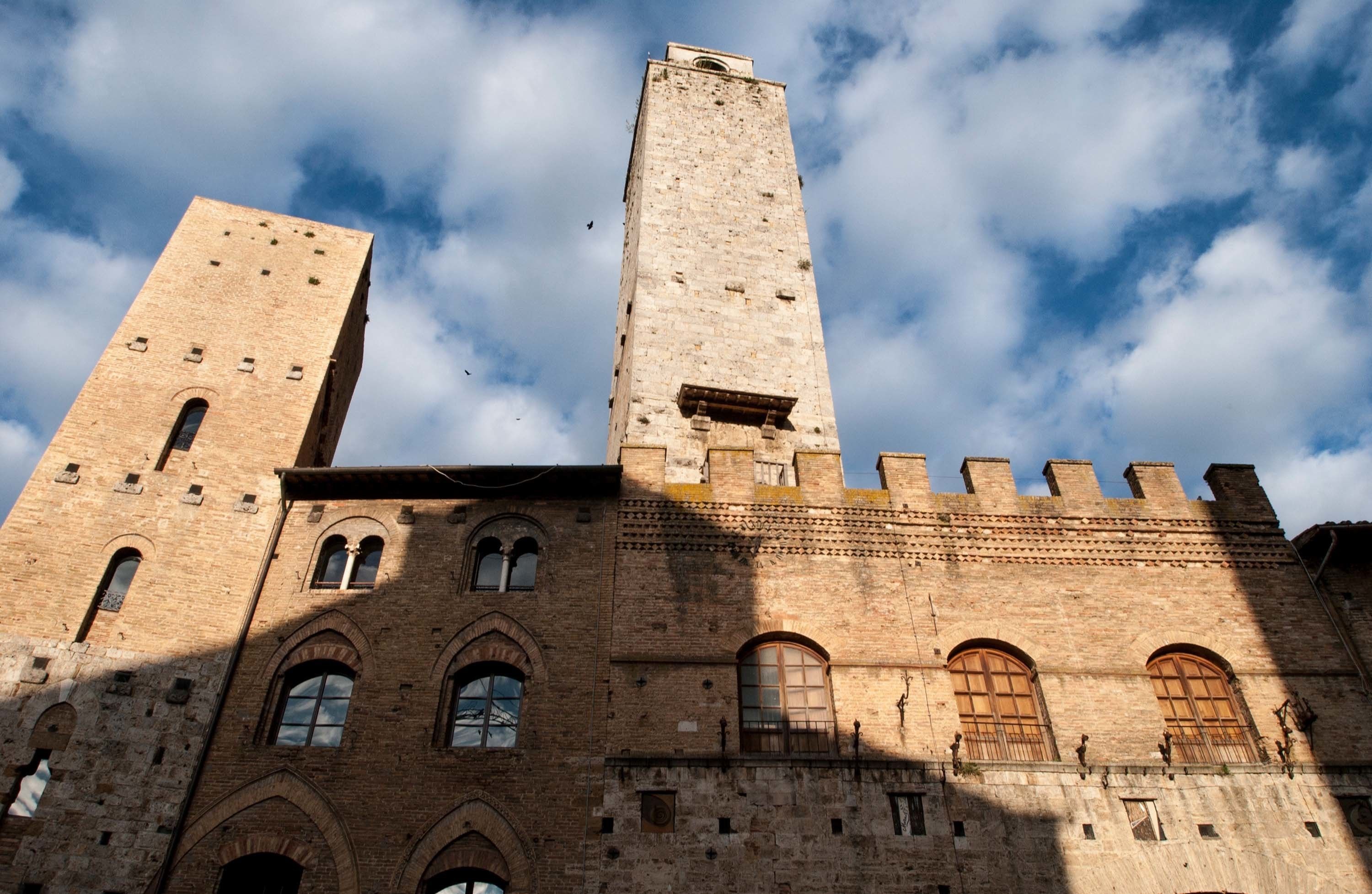 A historic building with two prominent towers and arched windows.