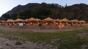 A row of tents with brick walls and a sign indicating 'ECOTERRA'. - Ecoterra Solace Resort (Narendranagar)