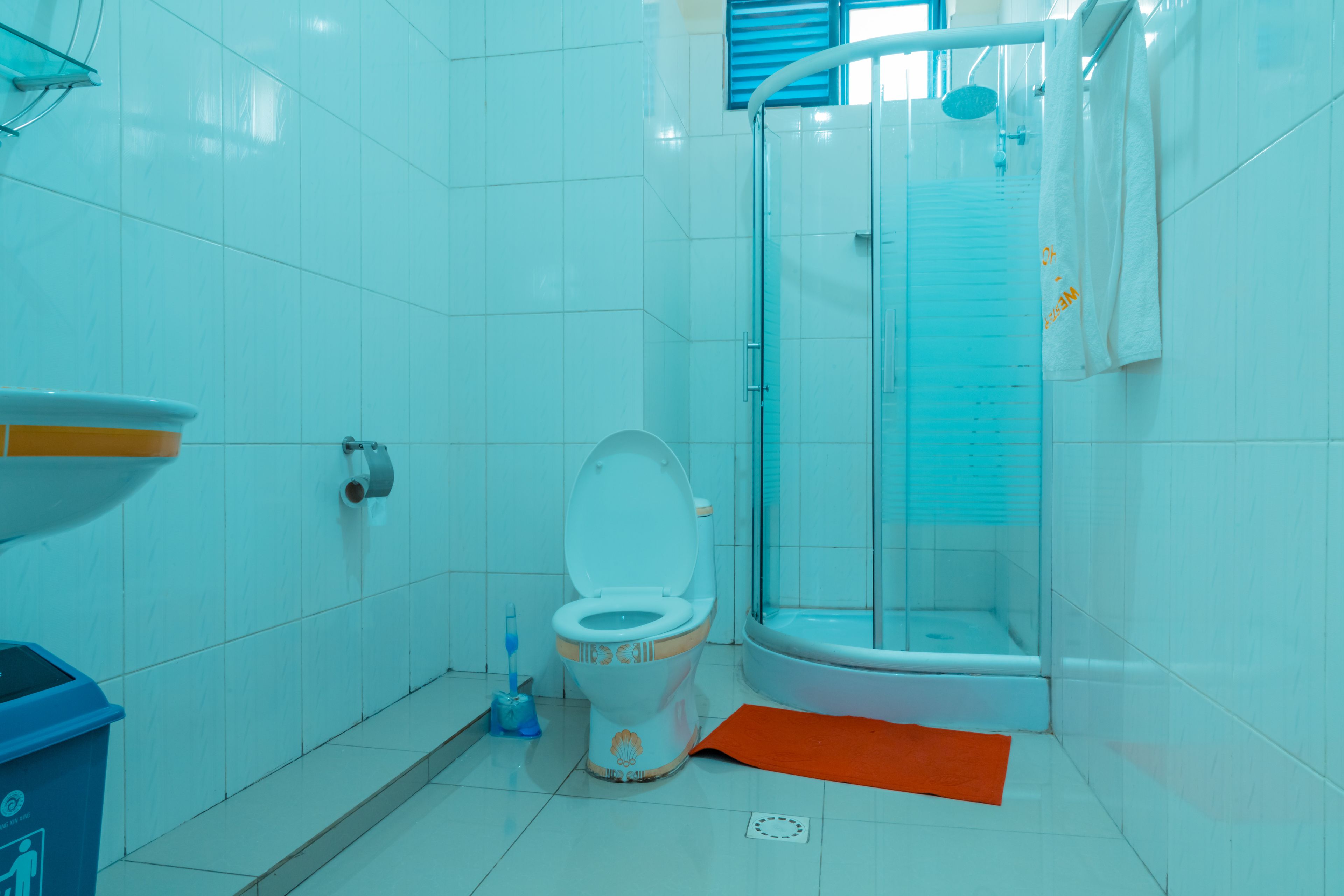 Une salle de bain équipée de toilettes, d’une douche et d’un lavabo.