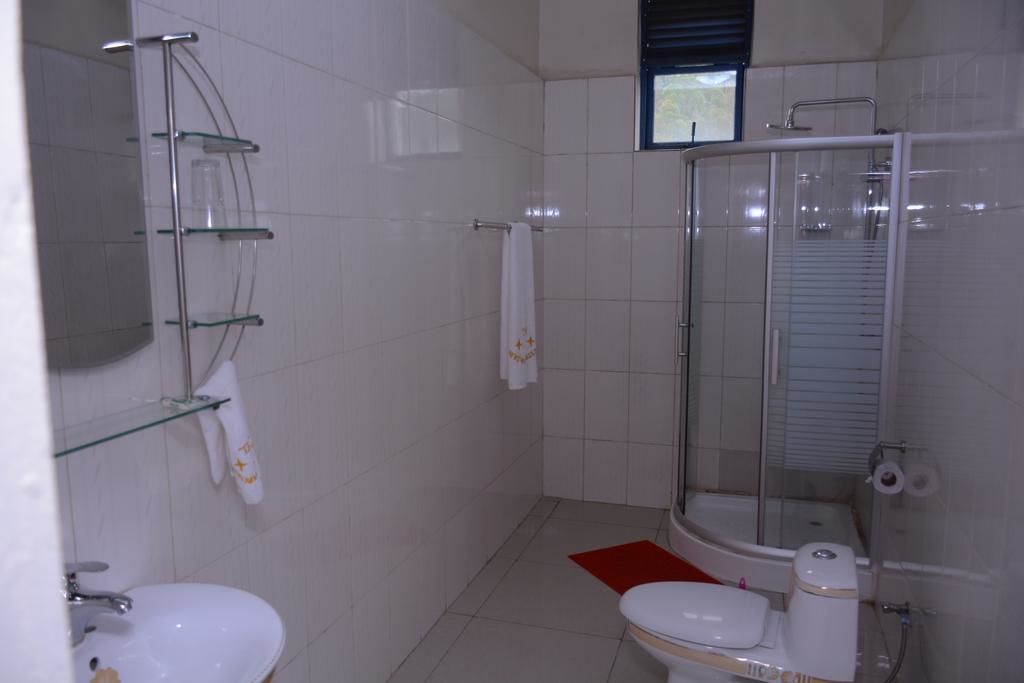 A modern bathroom with a glass-enclosed shower, a white sink, and a toilet.