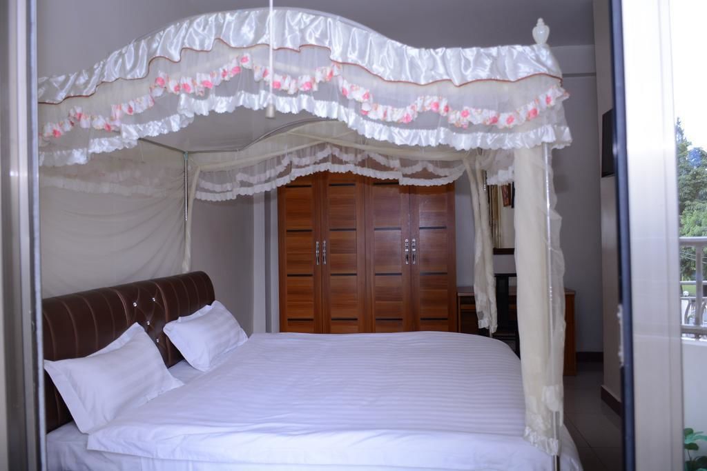 Un dormitorio con cama con dosel, armario de madera y vistas al exterior.