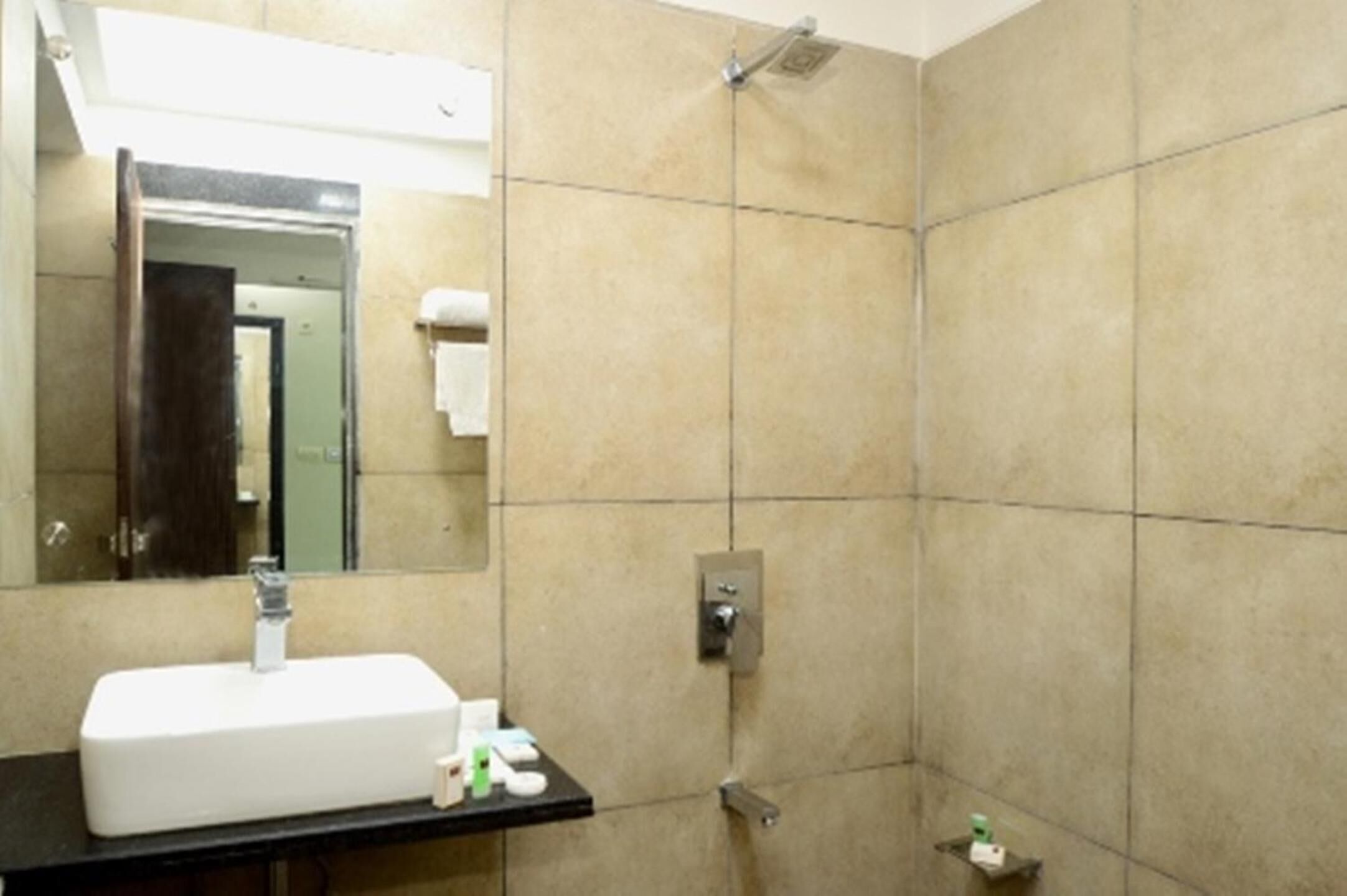 A bathroom with a white sink, mirror, and shower.