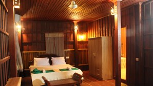 Habitación con paneles de madera, una cama, un banco y un armario.