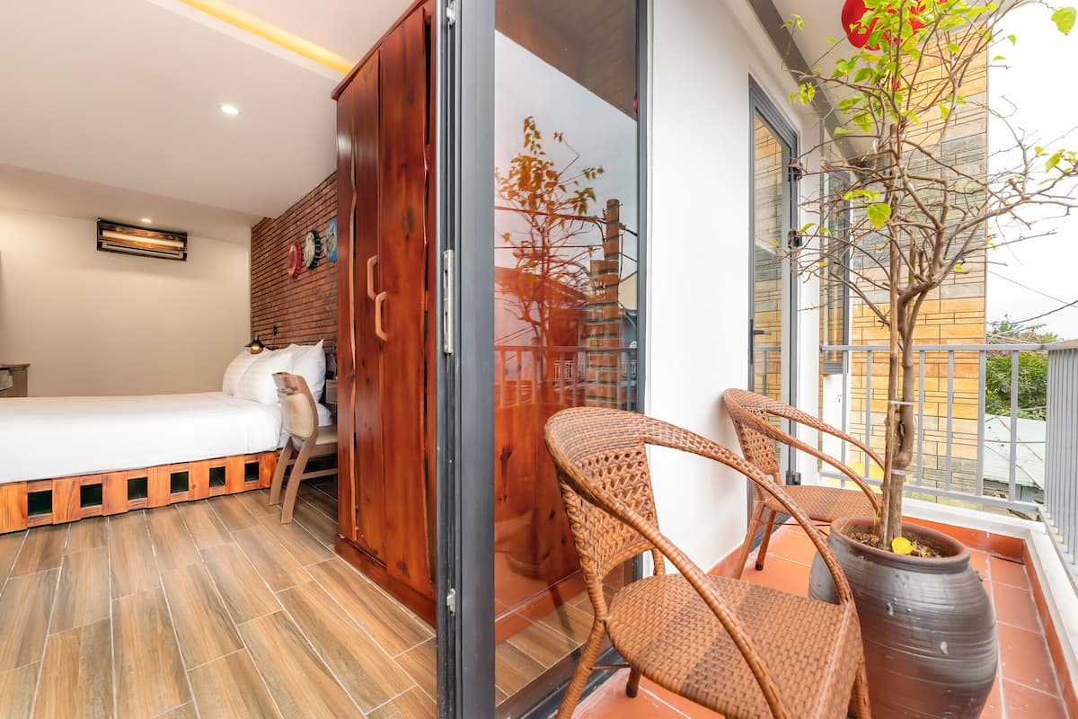 Une chambre à coucher avec un lit, une armoire et une plante en pot sur un balcon.