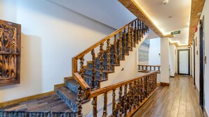Una escalera de madera con barandillas detalladas y un pasamanos de madera, que conduce a un piso superior.