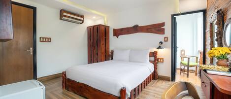 Une chambre à coucher avec un lit en bois, un bureau avec une chaise et un miroir au mur.
