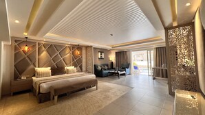 A spacious hotel room with a large bed, a sofa, and a balcony. - KaiSol Romance Resort (Sahl Hasheeh)