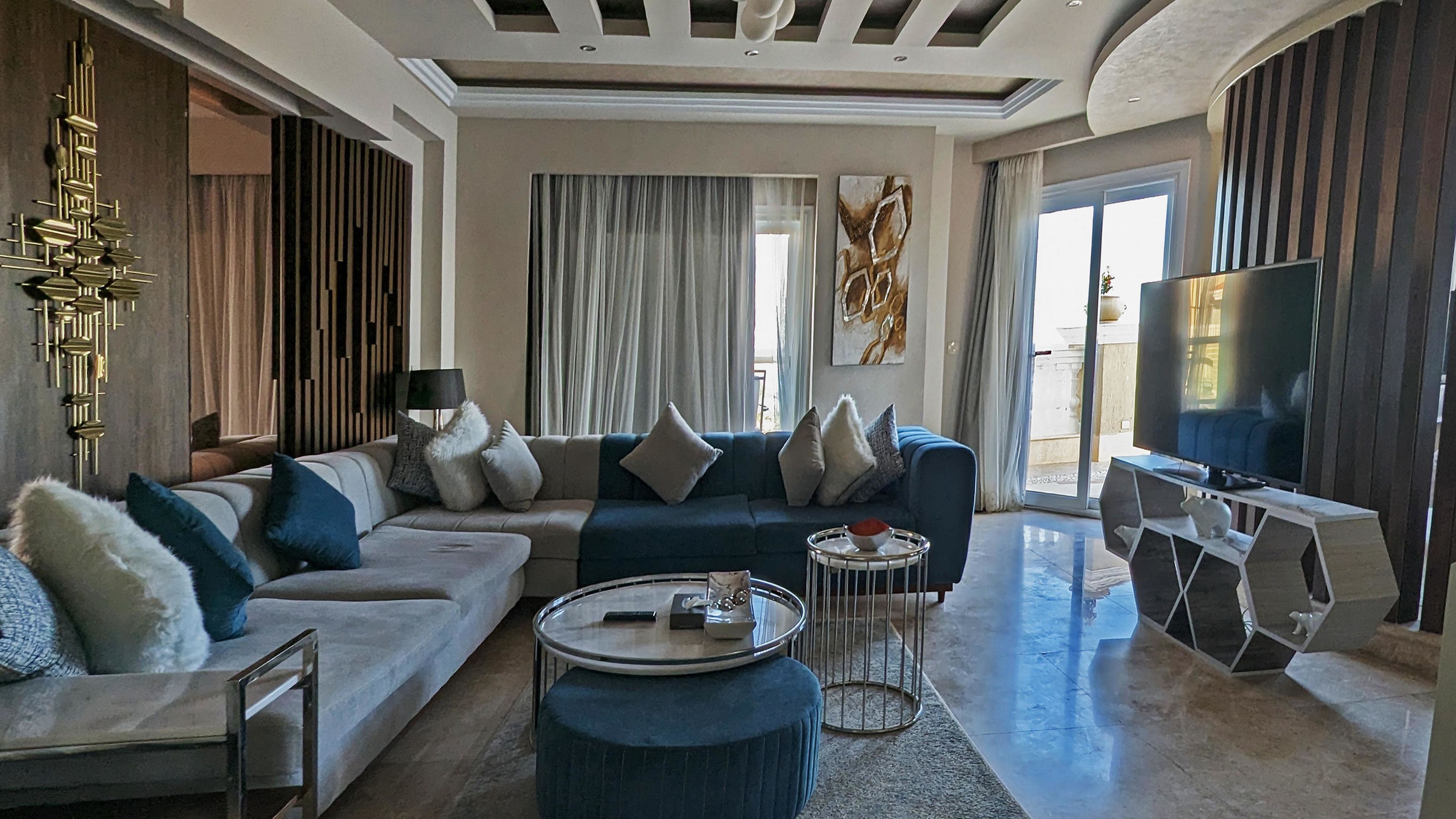 A modern living room with a sectional sofa, a coffee table, and a TV.