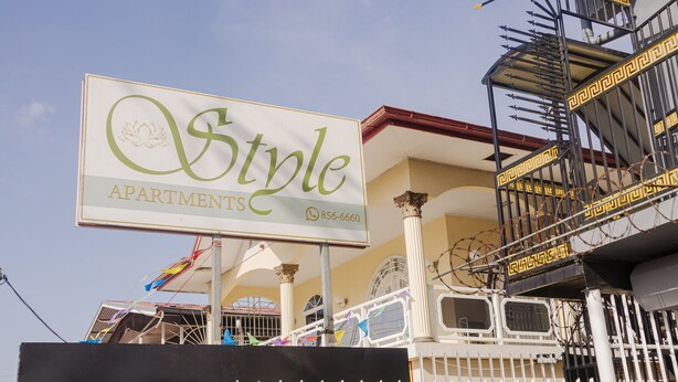 Placa com o nome 'Style Apartments' e um número de contato.